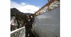 Photo from the original site: Paul at work beside a building in the mountains